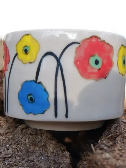 A close-up of a small bowl from the floral dinner set. The bright, simple flower paintings bring a pop of color and joy. It's perfect for serving sauces, spices, or small snacks.