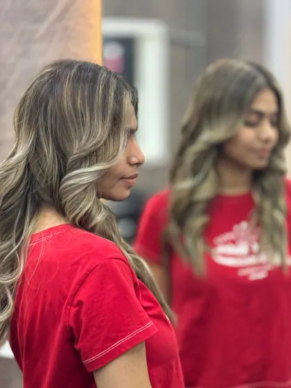 A side profile of a beautiful color and style by a student. Notice how the highlights frame the face and the curls add dimension. This is the kind of detail-oriented work we focus on.