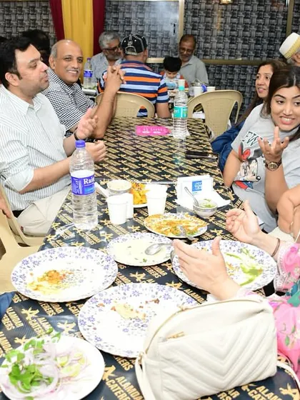 A table full of guests chatting and eating. We love the lively and friendly atmosphere.