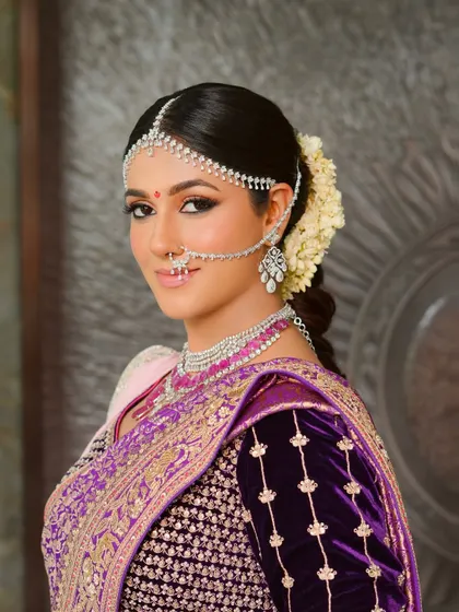 For this traditional ceremony, I designed a look that was both regal and ethereal. The makeup features softly sculpted features and luminous skin, harmonizing perfectly with the rich purple silk saree and classic diamond matha patti, creating a timeless bridal portrait.