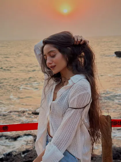 A gentle, happy pose with the sunset reflecting on the water. The golden hour on the beach is always a magical time.