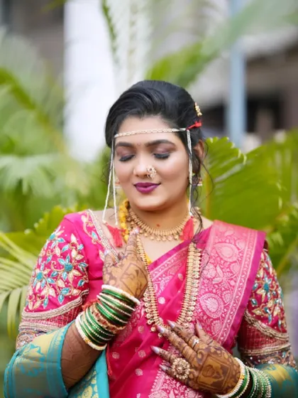 A close up of the bride's glowing makeup and traditional jewellery. The soft eyeshadow and bold lip color create a balanced and beautiful look.
