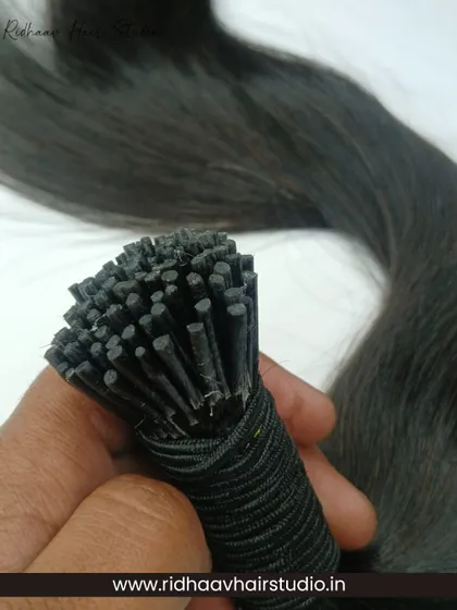 Our I-Tip Single Drawn Wavy Hair Extensions offer a natural taper and beautiful wave. This close-up shows the individual strands and tips, perfect for micro-link application.