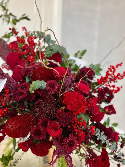 A close-up showing the details and textures in this all-red composition. Each flower is carefully placed to contribute to the overall vision of contrived, beautiful chaos.