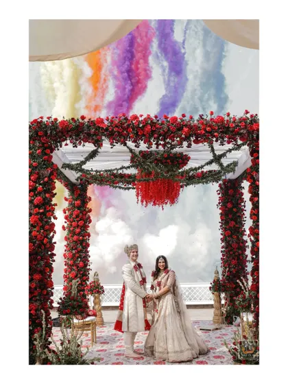 A creative shot with colored smoke bombs behind the couple at their beachside mandap in Goa.