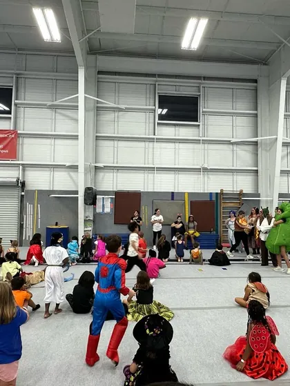A wide view of our gym during a themed Friday Fun Night, with kids in costumes gathered for games and activities. There's plenty of space for everyone to play and have fun.