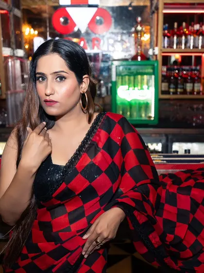 A direct and confident portrait of the influencer at the bar. This kind of shot is great for connecting with an audience and showcasing both the outfit and the individual's personality.