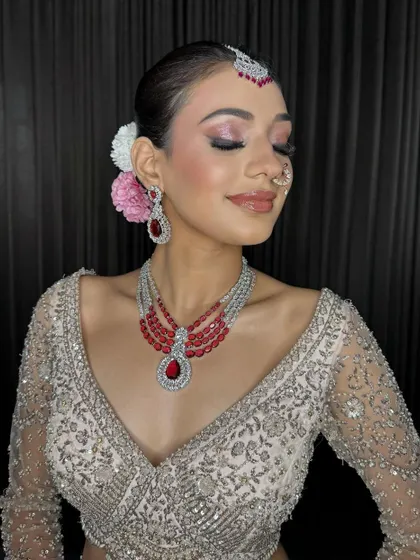 A close-up of the Sagan bride, with her eyes closed to show off the beautiful pink and silver eyeshadow. The fresh flowers in her hair add a lovely touch.