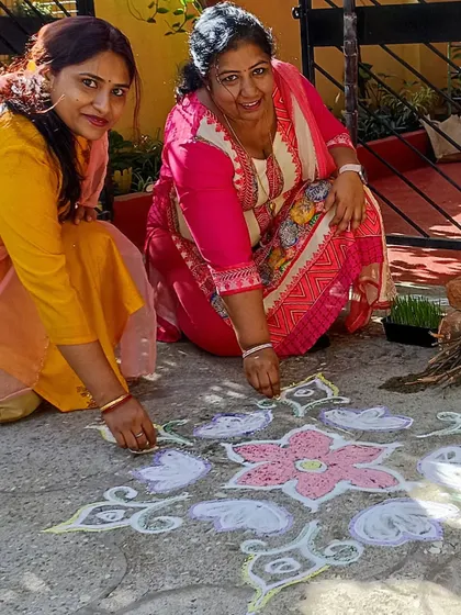 Our teachers creating a colorful rangoli on the ground for the Makar Sankranti festival.