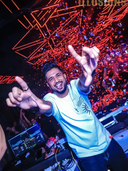 A fun, energetic shot of me with my tongue out, throwing up hand signs during a confetti drop. It's all about having a good time.