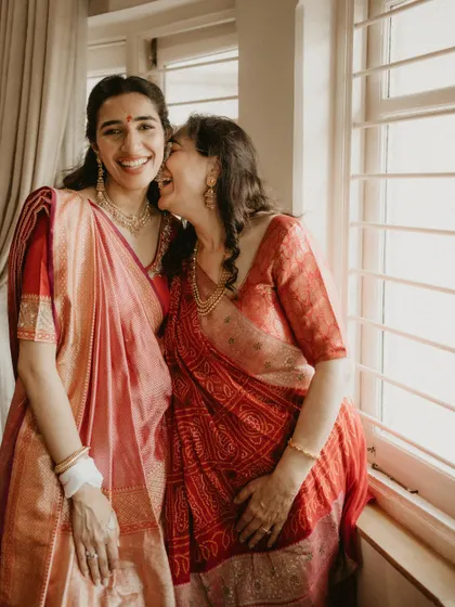 My Mandap, My Rules. The bride with her mother, both dressed in beautiful handloom sarees, challenging the idea that reds are reserved only for the bride.