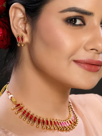 A close-up of a unique, enamel-work necklace with red stones, showcasing our ability to capture artisanal and handcrafted jewellery.