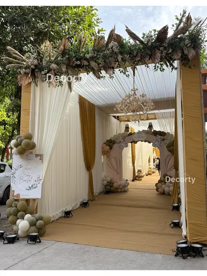 The grand entrance to the tented celebration, with a floral and pampas grass arrangement overhead.