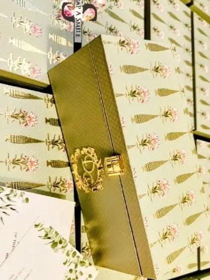 Here you can see the scale of a bulk order for the mint green wedding invitation boxes. Each box features a custom gold monogram with the couple's initials, adding a personal and luxurious touch.