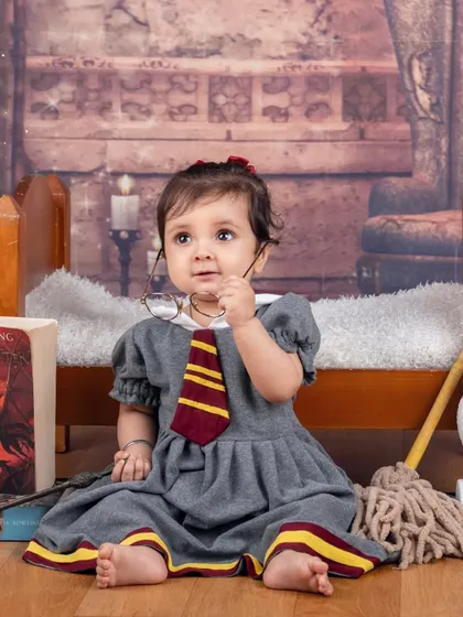 This little witch is taking a break from her magic lessons. A candid and cute moment from a Harry Potter themed session.
