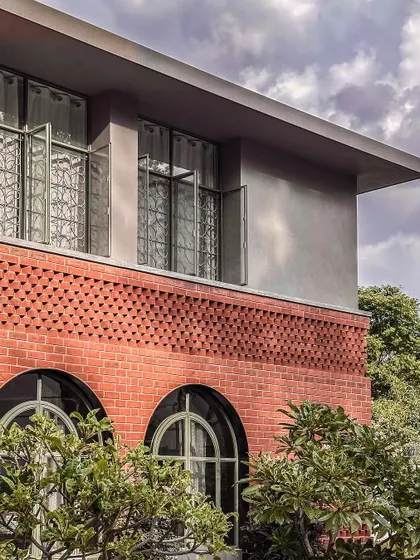 This exterior view of the Ferns Cottage highlights our focus on detailed craftsmanship. We combined classic arched windows on the ground floor with intricate brickwork and a modern, clean-lined upper level.