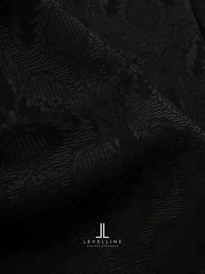 A sneak peek into our studio, showcasing the intricate black-on-black jacquard fabric and the design sketch for a client's special outfit.