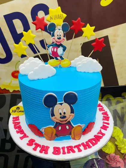 A cheerful 2.5kg Mickey Mouse cake with a blue combed-icing finish and star toppers.