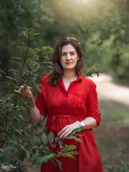 A duplicate of image 89, this outdoor portrait is a study in color and light. The subject's red dress contrasts beautifully with the soft greens of the forest, creating a striking and memorable image.