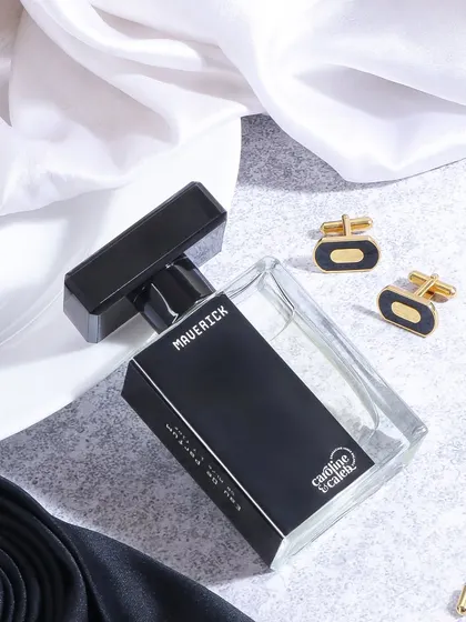 This flatlay for 'Maverick' perfume includes classic men's accessories like cufflinks and a tie pin. The styling creates an aura of timeless sophistication and formal elegance.