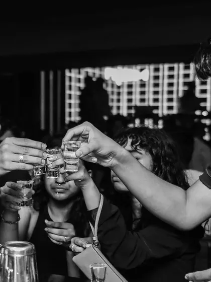 A group of friends enjoying shots at the bar. A great party is about more than just music; it's about creating a complete experience where people can celebrate and have a good time.