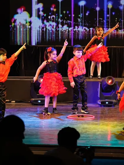 The kids pointing to the sky in a moment of shared joy and celebration during their performance.