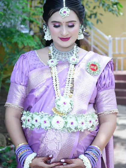 This photo beautifully captures the details of the necklace and kamarband, complete with an 'Aai' medallion pinned to her saree.