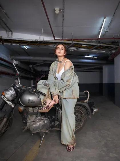 A powerful shot of Huma owning the frame. The combination of the bike, the distressed denim, and the leopard print heels is pure attitude.