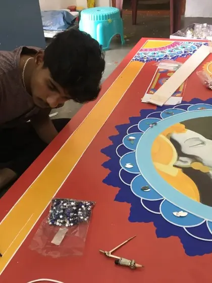 One of our artists carefully applying mirror pieces to a large Lippan art panel. This is a patient and precise process that gives the artwork its characteristic sparkle and texture.