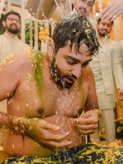 The groom gets the full Haldi treatment, complete with a dousing of cold water. His reaction is a perfect mix of shock and fun, a memory that will surely be cherished.