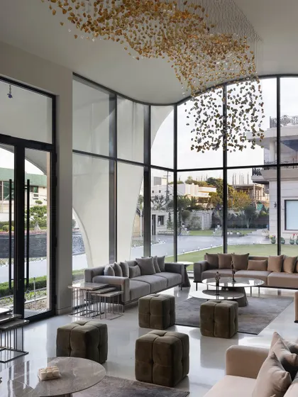 In this modern outhouse, we used seamless glass walls to dissolve the boundary between the living area and the garden. The double-height windows offer boundless views, making nature an integral part of the interior design and filling the space with light.