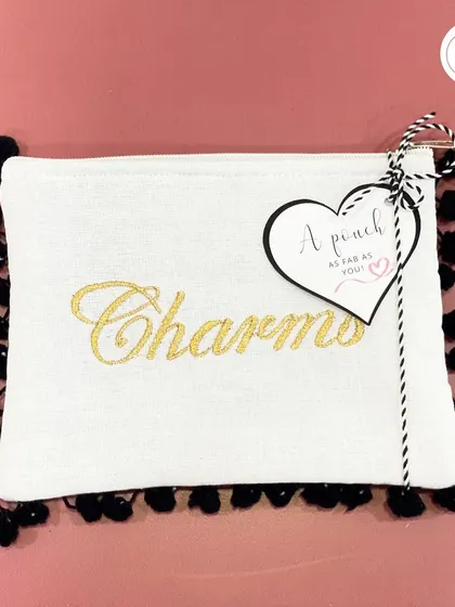 A close-up of the personalized pouch with a pom-pom trim, a fun and stylish accessory for any bridesmaid.