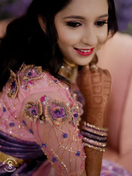 A close-up shot of the bride's beautiful reception look, highlighting her embroidered blouse and jewelry.