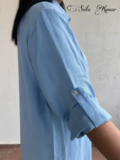 A close-up on the sleeve detail of the blue shirt dress, showing the quality craftsmanship and thoughtful design.