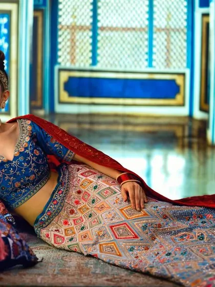 A luxurious room in a Mughal-inspired palace, created with projection. The vibrant blue walls and intricate details provide a stunning backdrop for this royal-themed bridal shoot.