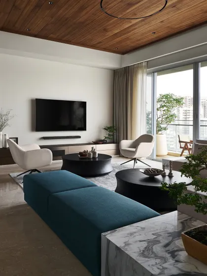 This view highlights the soft curves of our custom "Orbit" coffee tables and "Pivot" swivel armchairs. These organic forms were introduced to soften the clean, linear architecture of the living room.