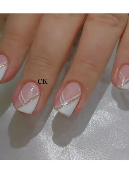 A close-up of the geometric French design, highlighting the clean lines and the touch of sparkle from the gold glitter.
