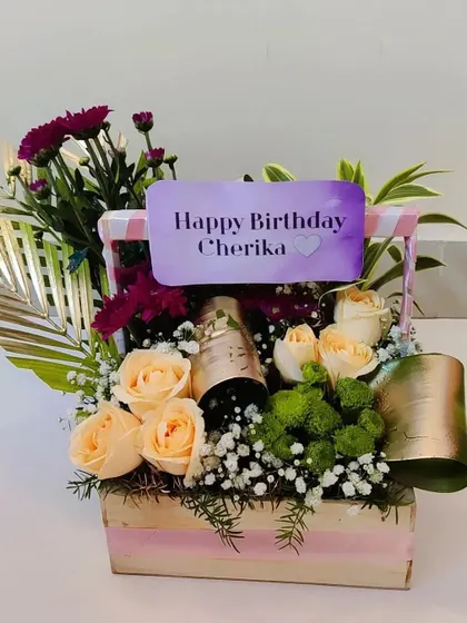 A close-up of the birthday basket with champagne, showing the beautiful peach roses and the personalized name card that makes the recipient feel truly special.