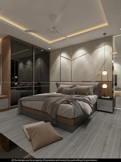 This master bedroom features a large, comfortable bed and a wardrobe with smoked glass doors, set against a wall with marble and gold-inlay details.