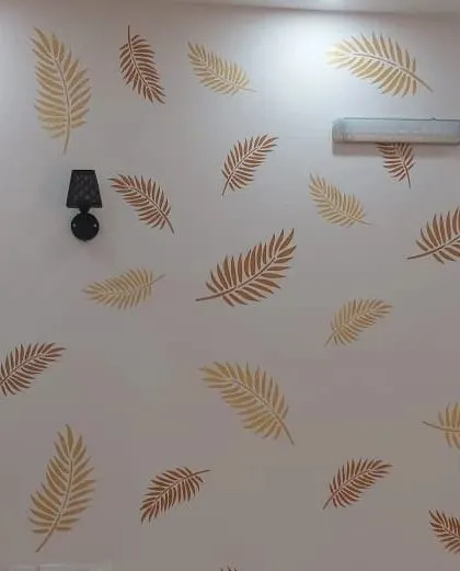 A delicate falling leaf stencil pattern in shades of gold and brown on a white wall, bringing a subtle touch of nature indoors.