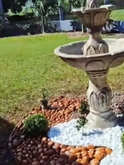 This classic style bird bath fountain becomes the centerpiece of the garden. We surrounded it with a mix of brown and white pebbles to create a clean and decorative base.