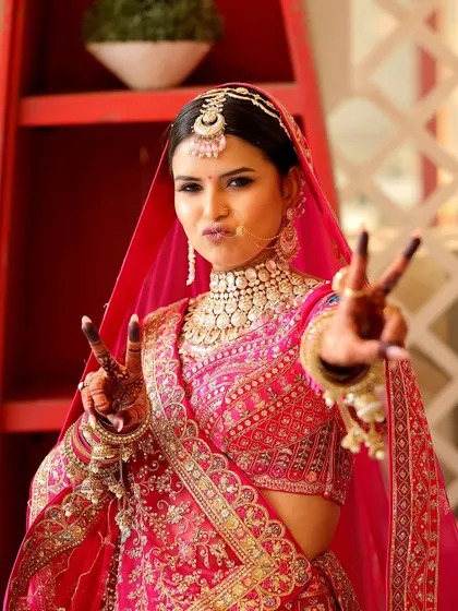 A fun and modern bridal portrait. The bride makes a peace sign, showing her personality and excitement on her wedding day, a candid moment we love to capture.