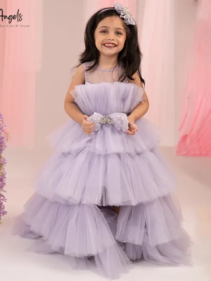 This high low gown in lilac features a multi layered tulle skirt and a bow embellished with crystals.