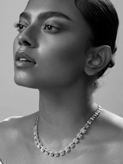 A classic shot focusing on a stunning diamond necklace. The angle beautifully showcases the design and sparkle of the piece against the skin.