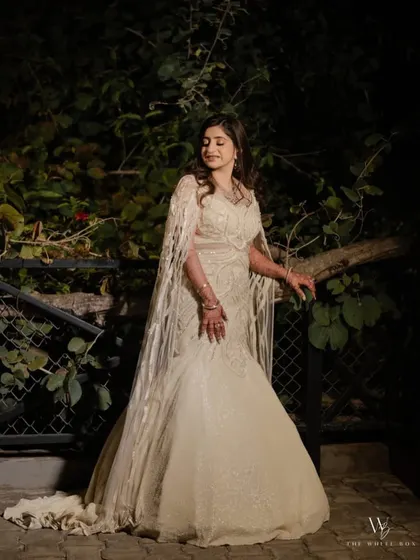 Draped in a sea of sequins and sculpted to perfection, this ivory fish-cut silhouette with floor-sweeping sleeves redefines elegance.