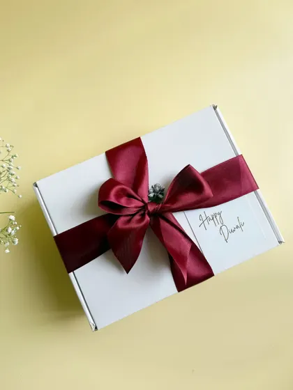 Simple, elegant, and heartfelt. This beautifully wrapped Diwali gift box with a rich maroon satin ribbon is perfect for conveying warm festive wishes to clients and employees.