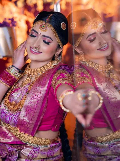 A beautiful moment captured during a Telugu muhurtham demo class. The reflection shows the makeup from another angle, highlighting the flawless finish and the intricate details of the hair and jewellery.