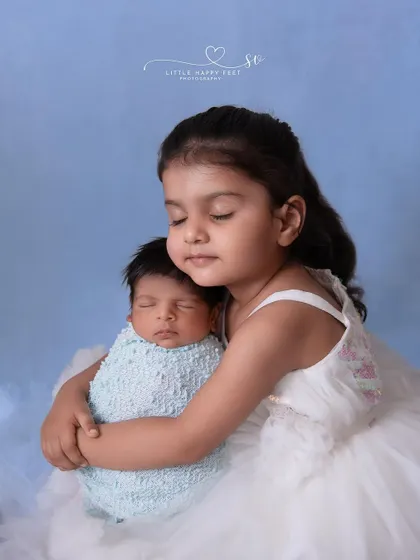 A big sister's first hug. The look of wonder and love on her face as she holds her new baby brother is a memory to be cherished forever.