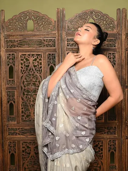A more expressive, artistic pose that conveys emotion. The lighting highlights the model's features and the texture of the saree, creating a moody and captivating portrait.