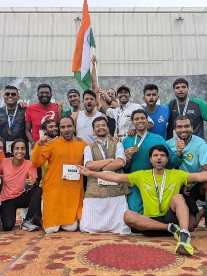 The entire running crew celebrates together on stage, a perfect picture of community, achievement, and fun.